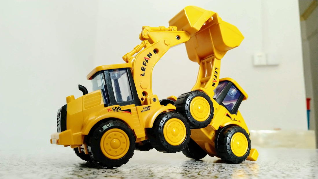 a yellow toy bulldozer is on the floor